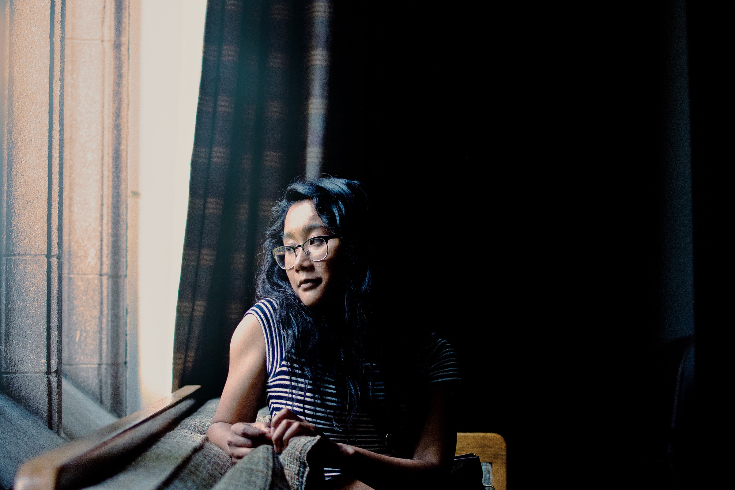 Woman sitting on sofa looking out window